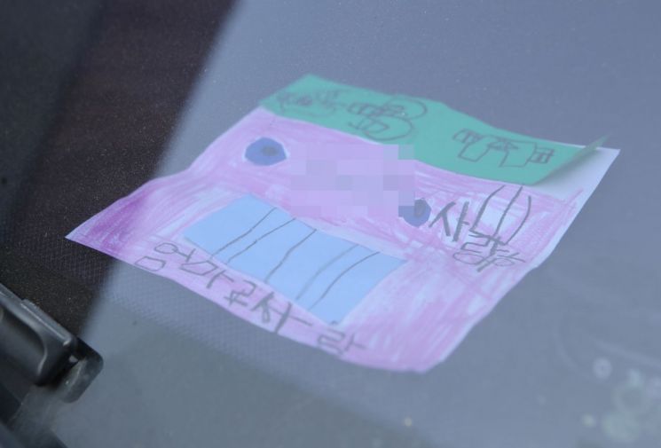 지난 18일 인천시 미추홀구 한 주택에서 숨진 채 발견된 일가족 소유 차량에 아이가 쓴 것으로 보이는 쪽지가 놓여 있다. [이미지출처=연합뉴스]