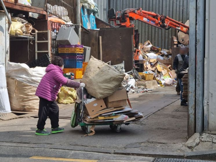 20일 오전 서울 영등포구 대림동 일대 고물상 앞. 한 노인이 가져온 폐지와 재활용품의 무게를 재기 위해 기다리고 있다/사진=황서율chestnut@