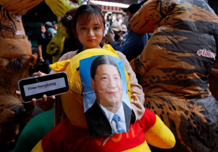 지난해 11월 태국 방콕에서 한 시위 참가자가 시진핑 중국 국가주석 사진을 붙인 '곰돌이 푸' 인형을 껴안은 채 '홍콩을 해방하라'(Free Hong Kong)는 문구의 손팻말을 들고 있다. 사진제공=로이터·연합뉴스