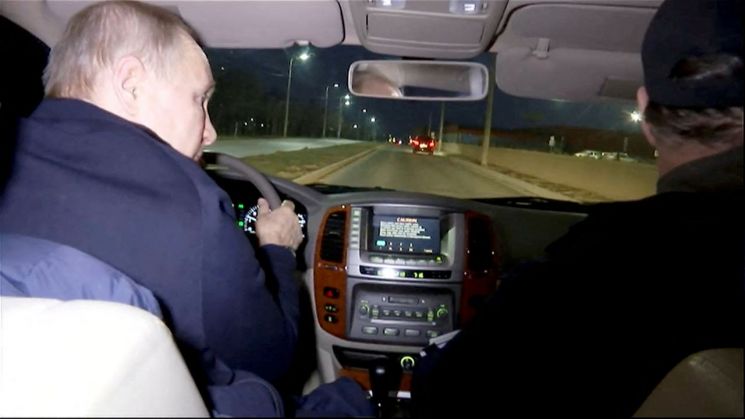 블라디미르 푸틴 러시아 대통령(왼쪽)이 지난 18일(현지시간) 밤 우크라이나내 자국군 점령지인 마리우폴을 방문해 차량을 운전하고 있다. [이미지출처=연합뉴스]