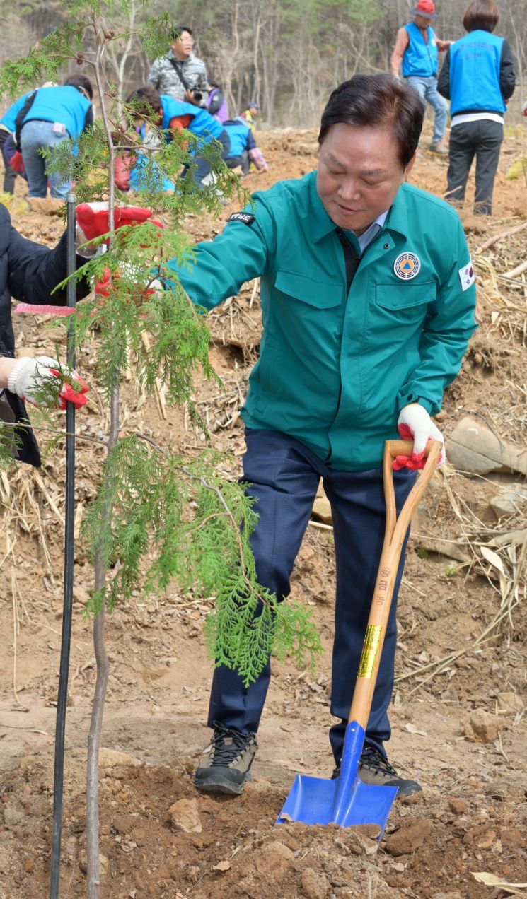 박완수 경남도지사가 밀양에서 열린 희망나무심기 행사에서 심은 편백나무를 고정하고 있다. [사진제공=경남도청]