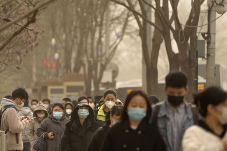 22일 중국 베이징 중심가에서 마스크를 쓴 시민들이 거리를 걷고 있다. [이미지출처=AP연합뉴스]