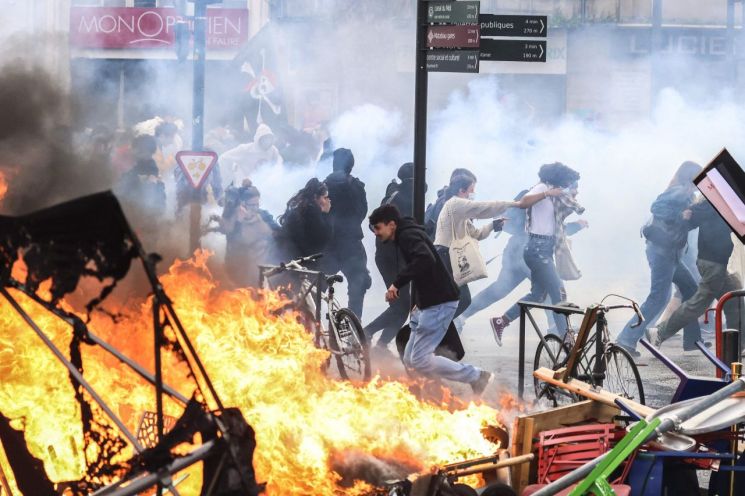 프랑스 전역에서 정부의 연금개혁에 반대하는 시위가 지속되는 가운데 23일(현지시간) 남부 툴루즈에서 시위 참가자들이 경찰이 쏜 최루탄 가스를 피해 달아나고 있다. 이날 프랑스 8개 주요 노동조합이 전국 곳곳에서 개최한 9차 시위에는 내무부 추산 약 108만9천명이 참가했다. 이날 시위로 전국에서 80명 이상이 체포되고 진압 과정에서 경찰 최소 123명이 다쳤다. [이미지출처=연합뉴스]