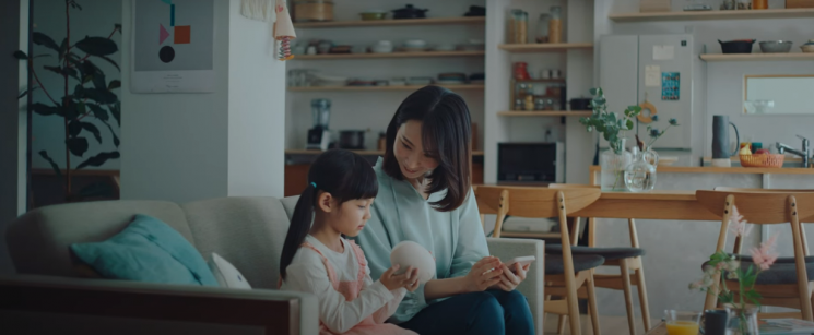 코에모 광고의 한 장면. 부모 목소리로 녹음한 AI 스피커를 아이에게 들려주고 있다.(사진출처=코에모 홈페이지)