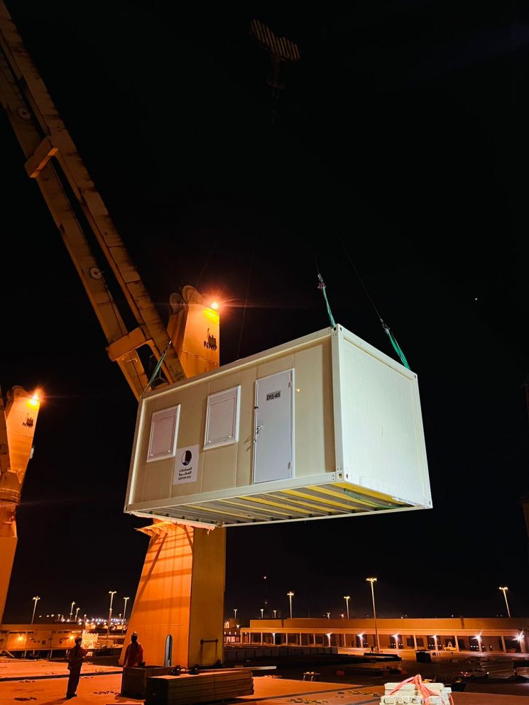 지난해 카타르월드컵 숙박시설로 사용했던 임시주택 컨테이너586개를 ‘HMM 울산호’에 선적하고 있다. [사진제공=HMM]