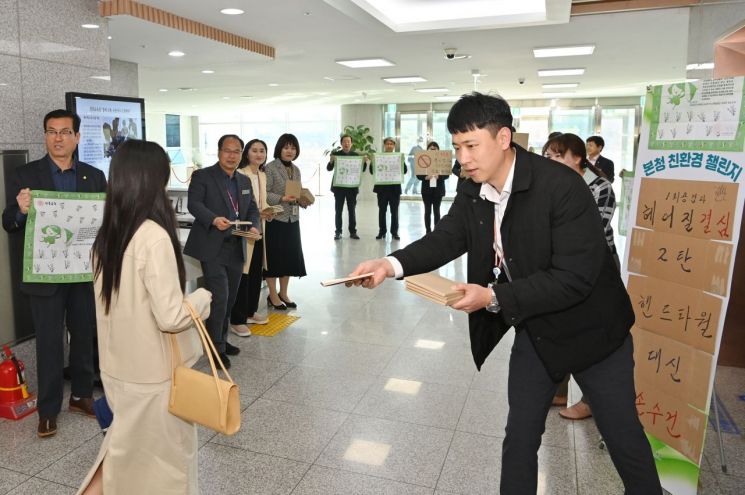 경북교육청이 청사 현관에서 ‘1회용 종이타월 대신 손수건 사용’ 캠페인을 펼치며 직원들에게 손수건을 나눠주고 있다.