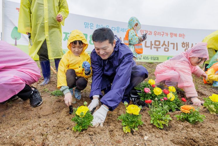 김태우 서울 강서구청장(정면 왼쪽 두 번째)이 5일 오전 공항동 406-8 일대에서 열린 ‘제78회 식목일 나무심기 행사’에서 아이와 함께 꽃을 심고 있다.