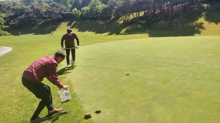 용인시 공무원이 농약 잔류량 검사를 위해 골프장에서 시료를 채취하고 있다.