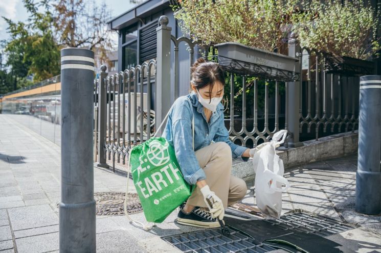 롯데백화점이 지난해 가을 진행한 '시티플로깅' 행사에 참여한 시민이 쓰레기를 줍고 있다[사진제공=롯데백화점].