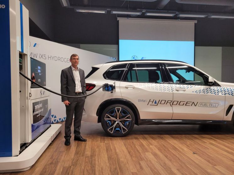 BMW 수소차 프로젝트를 총괄하는 위르겐 굴트너 박사가 iX5 하이드로젠에 수소 충전을 시연하고 있다.[사진=우수연 기자]