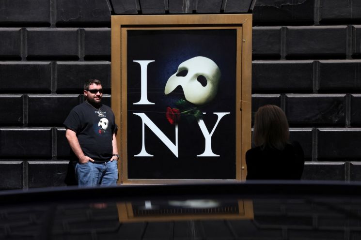 미국 뉴욕 마제스틱 극장에서 열리는 '오페라의 유령' 마지막 공연에 앞서 한 관객이 포스터 옆에서 기념사진을 촬영하고 있다. [사진출처=로이터연합] [이미지출처=로이터연합뉴스]