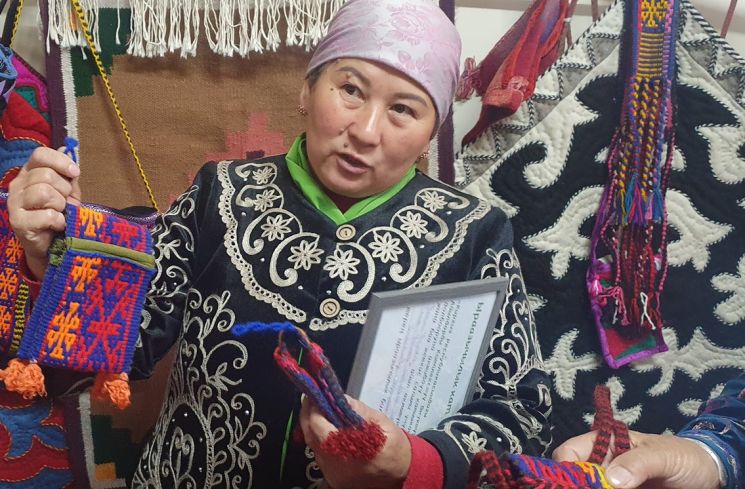 12일(현지시간) 키르기스스탄 오쉬의 카라 칼자군에 속한 사리-카무쉬 마을의 다목적여성센터에서 마을 여성인 마따이바 아이굴씨가 한국 취재진에게 직접 제작한 수공예품을 소개하고 있다. [외교부 공동취재단(오쉬)]