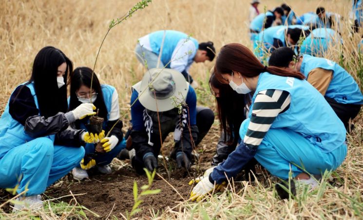 지난 14일 서울 성동구 살곶이공원에서 두산퓨얼셀 임직원들이 관목을 식재하고 있다. [사진제공=두산퓨얼셀]