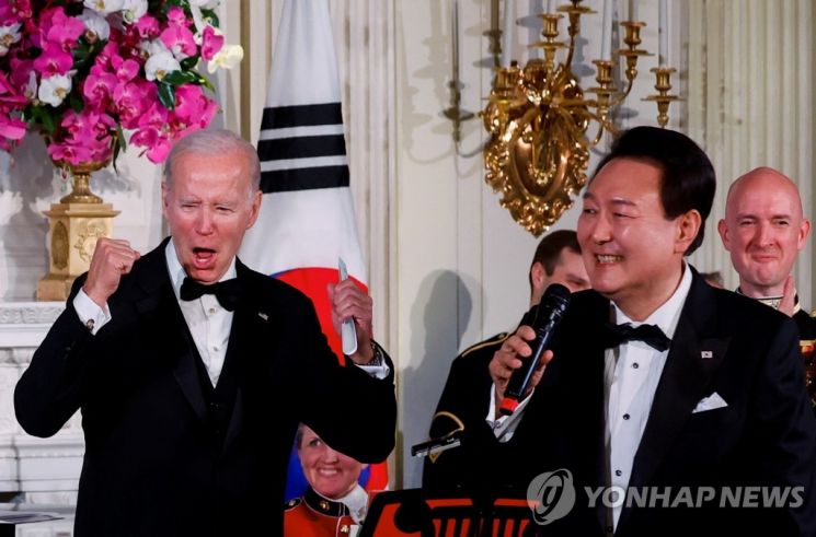조 바이든 미국 대통령(왼쪽)이 지난 26일(현지시간) 워싱턴DC 백악관에서 열리는 한미 정상 국빈만찬에서 윤석열 대통령이 부르는 노래에 호응하고 있다. [이미지출처=연합뉴스]