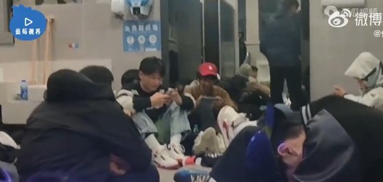 하루 묵을 곳을 찾지 못한 투숙객이 화장실 바닥에 앉아있는 모습. [이미지출처=웨이보]