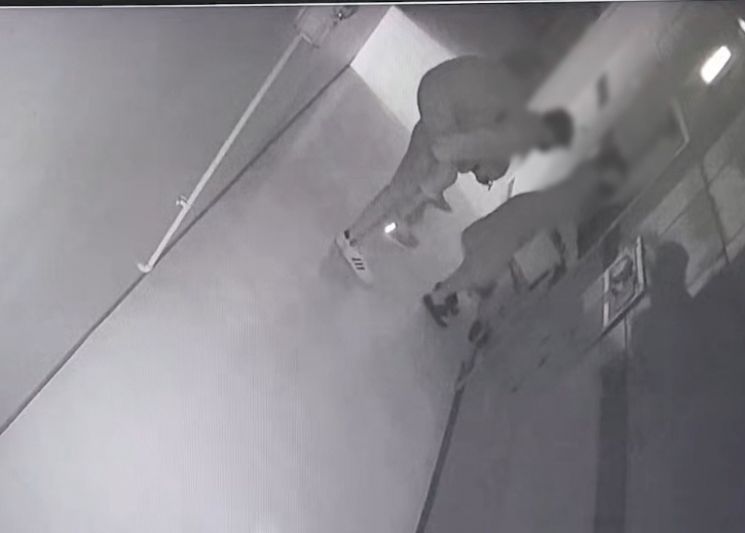 김 형사가 불이 난 건물 13층에서 80대 할머니를 둘러업고 비상계단을 향하고 있다. [이미지출처=부산경찰청]