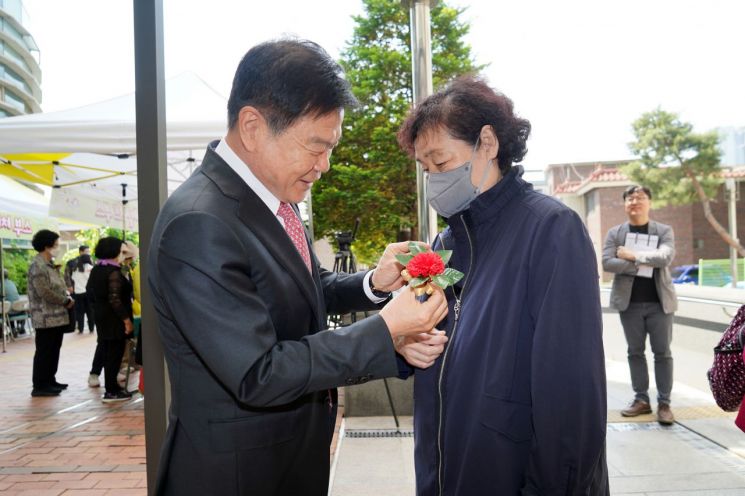 이필형 동대문구청장(사진 왼쪽)이 시립동대문노인종합복지관의 어르신 감사 축제에 참석해 직접 카네이션을 달아드리고 있다.