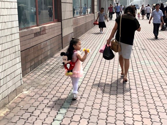 평양 시내에서 미키마우스 가방을 맨 아이 [이미지출처=연합뉴스]