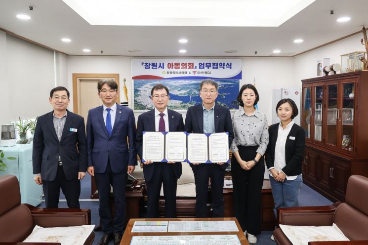 Gyeongnam Changwon Special City Council and Masan YMCA signed a business agreement to organize and operate the Changwon City Children's Council and are taking pictures for authentication. [사진제공=창원시의회]