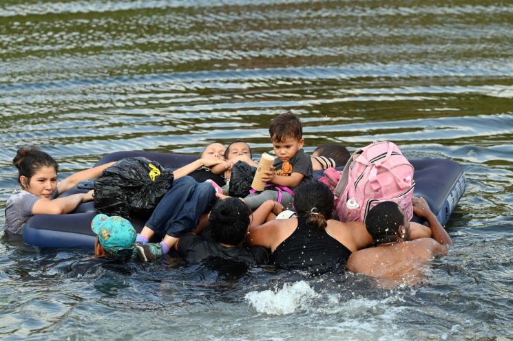 미국 입국을 희망하는 이주민들이 11일(현지시간) 매트리스에 아기를 태운 채 미국과 국경을 맞댄 멕시코 북부 타마울리파스주(州)의 리오그란데강을 건너고 있다. [사진=AFP/연합뉴스]