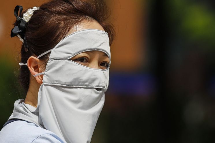 지난달 27일 말레이시아 쿠알라룸푸르의 한 여성이 햇볕과 더위를 피하고자 냉기 마스크로 얼굴 전체를 가린 모습. 쿠알라룸푸르=EPA·연합뉴스