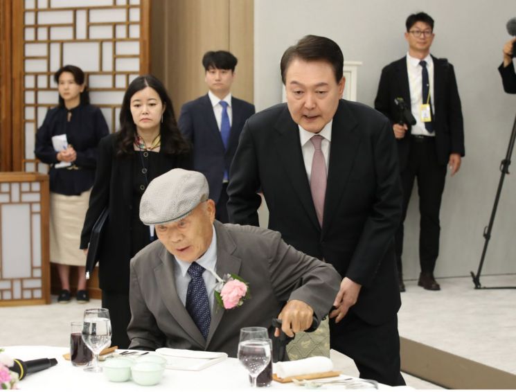 윤석열 대통령이 15일 서울 용산 대통령실 청사에서 열린 제42회 스승의 날 기념 현장교원 초청 오찬 간담회에서 충암고 시절 은사인 최윤복 전 교장의 착석을 돕고 있다. [이미지출처=연합뉴스]