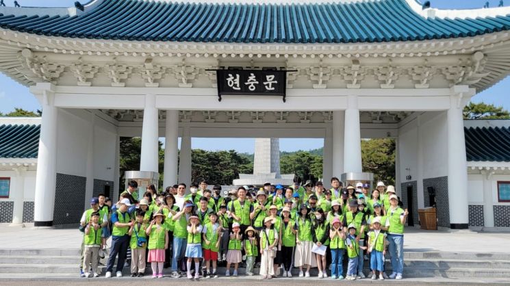 현대엔지니어링 임직원 및 가족들이 지난 20일 서울 동작구 국립서울현충원에서 묘역 정화 봉사활동을 한 뒤, 기념촬영을 하고 있다.[사진제공=현대엔지니어링]