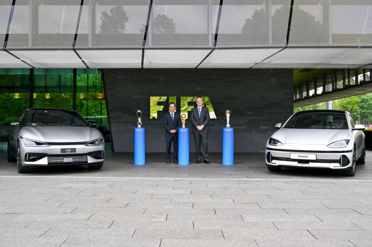 김걸 현대차그룹 기획조정실장(왼쪽)과 지안니 인판티노FIFA 회장(오른쪽)이 조인식 이후 아이오닉 6, EV6 옆에서 기념 촬영을 하고 있다. [사진제공=현대자동차그룹]