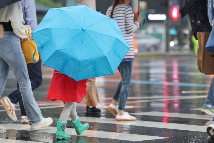 27일 서울 광화문네거리에서 어린이가 우산을 쓰고 횡단보도를 건너고 있다. [사진출처=연합뉴스]