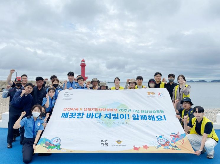 해양 환경 전화 활동 캠페인에 참여한 삼진어묵과 남해지방해양경찰 직원들이 단체 기념사진을 찍고 있다.