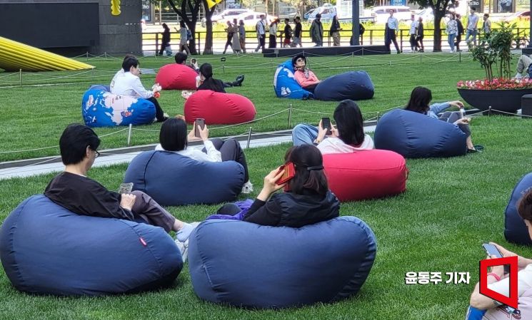 지난달 25일 직장인들이 점심시간에 잔디밭에서 휴식을 취하고 있다. 사진=윤동주 기자 doso7@