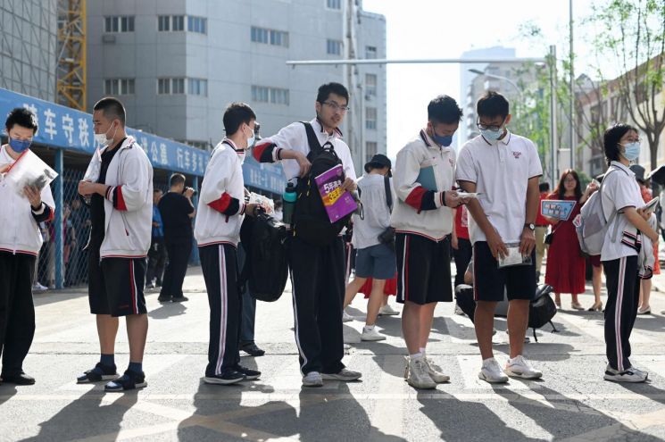 중국의 대학 입학시험 가오카오(高考)를 치르는 수험생들이 지난 7일 베이징의 시험장 앞에 줄 서 있다. 이날부터 이틀간 치러지는 올해 가오카오에는 역대 최대인 1천291만 명이 응시했다.