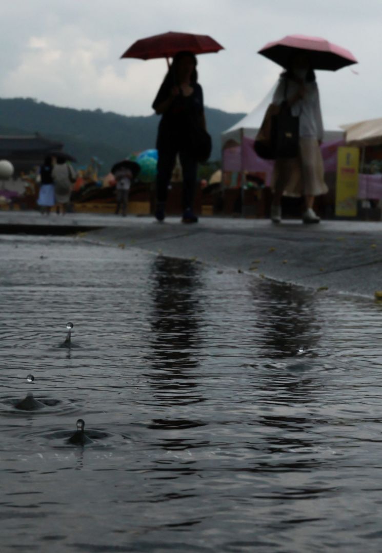 비가 내린 서울 세종대로 광화문광장에서 관광객과 시민들이 우산을 쓴 채 이동하고 있다. [이미지출처=연합뉴스]
