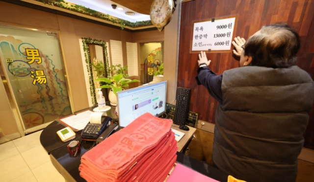 서울 종로구의 한 목욕탕에서 업주가 인상된 요금표를 만지고 있다. [사진출처=연합뉴스]