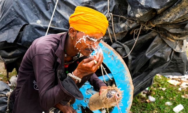 지난 18일(현지시간) 인도 북부 우타르프라데시주 랄리트푸르 지역에서 한 남성이 더위를 식히기 위해 얼굴에 물을 뿌리고 있다. [이미지출처=연합뉴스]