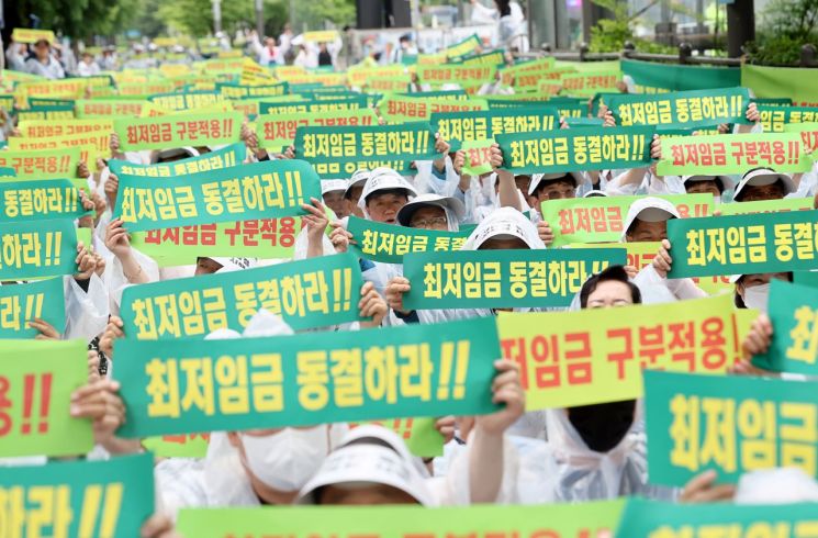 21일 오후 서울 국회의사당역 인근에서 열린 최저임금 동결 촉구 결의대회에서 소상공인연합회원들이 관련 손피켓을 들어보이고 있다. 사진=연합