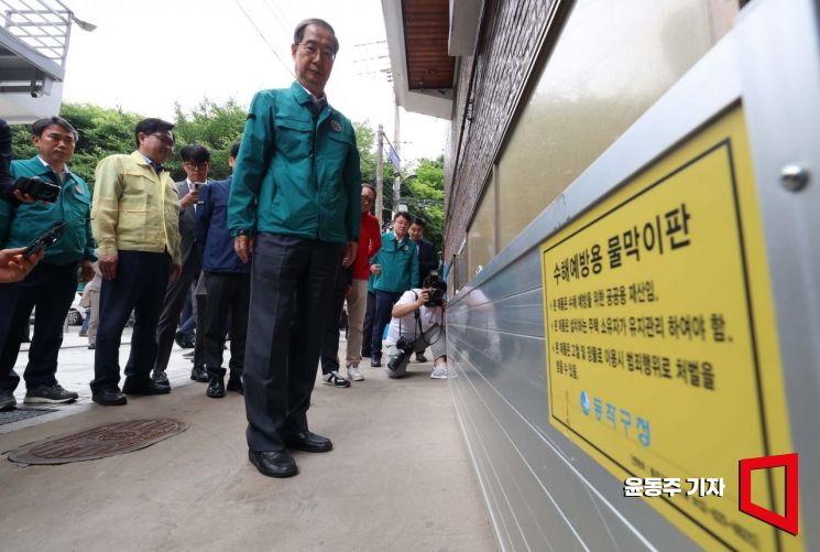 본격적인 장마를 앞둔 12일 서울 동작구 도림천 저지대 주택가를 찾은 한덕수 총리가 설치된 수해예방용 물막이판을 살펴보고 있다. 사진=윤동주 기자 doos7@