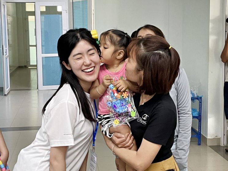 ‘베트남 얼굴기형 어린이 무료수술’ 행사에 참여한 SK 대학생 자원봉사단 ‘SK 써니’ 참가자들이 수술한 어린이들과 가족을 위로하는 봉사 활동을 펼치고 있다. 사진제공=SK