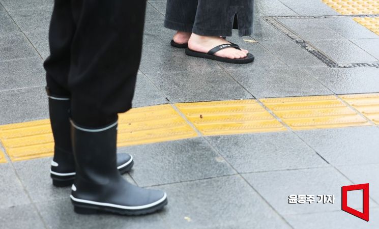 장마전선이 북상하면서 서울 등 수도권에도 장맛비가 내리기 시작한 26일 서울 광화문광장을 지나는 시민들이 신은 샌들과 장화가 묘한 대비를 이루고 있다. 사진=윤동주 기자 doso7@