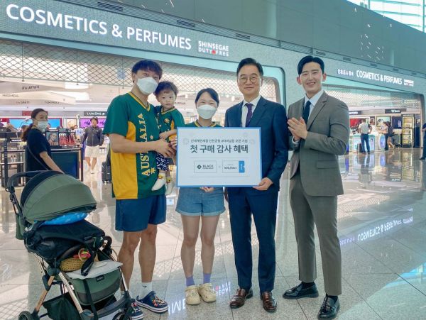 신세계면세점 인천공항 제2터미널점에서 양호진 신세계디에프 영업본부장(오른쪽에서 구 번째)이 첫 구매고객 가족 등과 기념 사진을 촬영하고 있다[사진제공=신세계디에프].