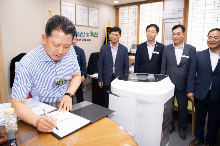 사무실에서 수발해온 결재 서류를 김 시장에게 전달해 서류를 결재받는 서빙로봇.