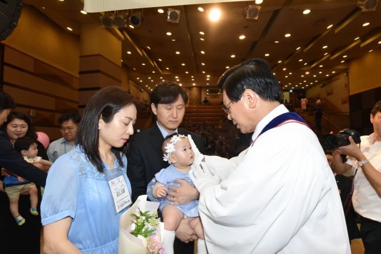 이영훈 여의도순복음교회 담임목사가 헌아식에 참여한 아이에게 안수기도하고 있다. [사진제공=여의도순복음교회]
