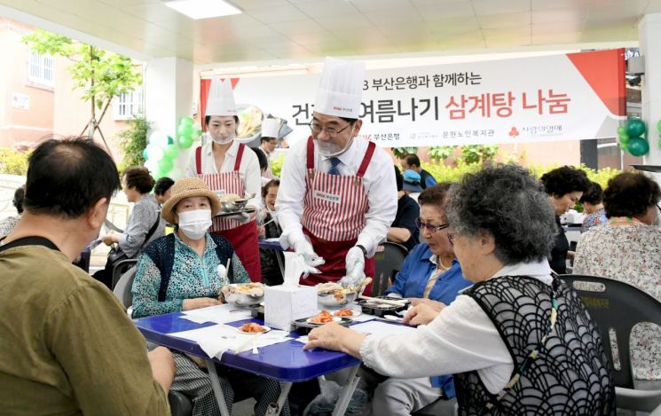 BNK부산은행 방성빈 은행장 등 임직원들이 지역 어르신에게 삼계탕을 대접하고 있다.