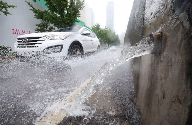 전국적으로 장맛비가 내린 11일 오후 서울 중구 서소문고가차도 배수로를 따라 흘러내린 물이 인근 도로로 흘러내리고 있다. [이미지출처=연합뉴스]