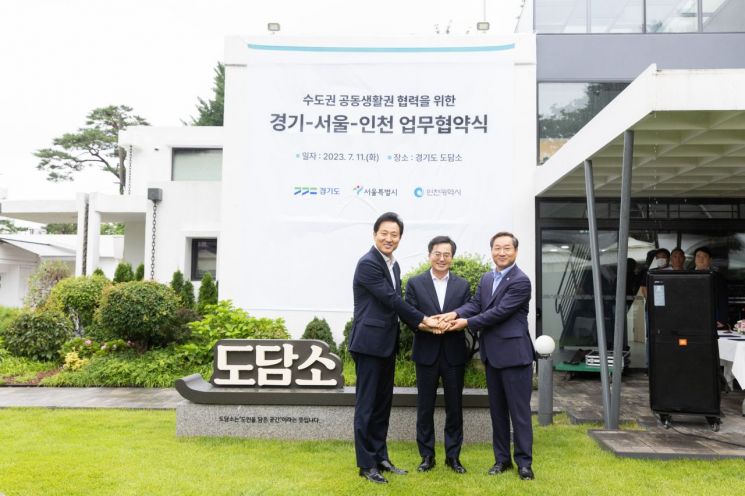 김동연 경기도지사(중앙)가 11일 수원 도담소에서 수도권 공동생활권 협력을 위한 업무협약을 체결한 뒤 오세훈 서울시장(왼쪽), 유정복 인천시장과 손을 잡고 기념사진을 찍고 있다.