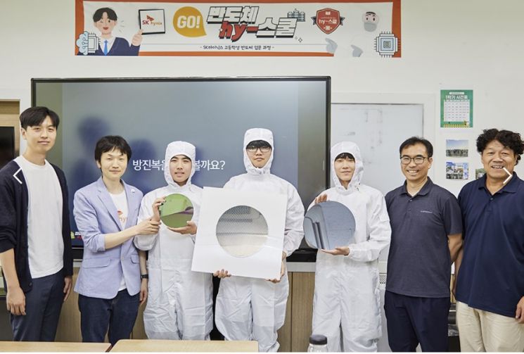 방진복을 입은 삼일공고 학생들이 웨이퍼를 들고 기념촬영하는 모습.[사진제공=SK하이닉스]