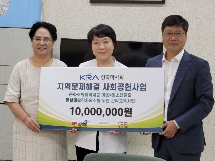 한국마사회 최만규 부산고객지원처장(오른쪽 첫번째)이 김해시 올키즈스트라 관악단 관계자에게 후원금을 전하고 있다.