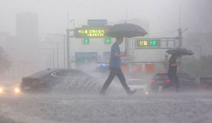 서울 전역에 호우주의보가 발효되는 등 본격적인 장마가 시작된 13일 비가 쏟아지는 서울 여의대로 횡단보도 위로 우산을 쓴 시민들이 지나고 있다. [이미지출처=연합뉴스]