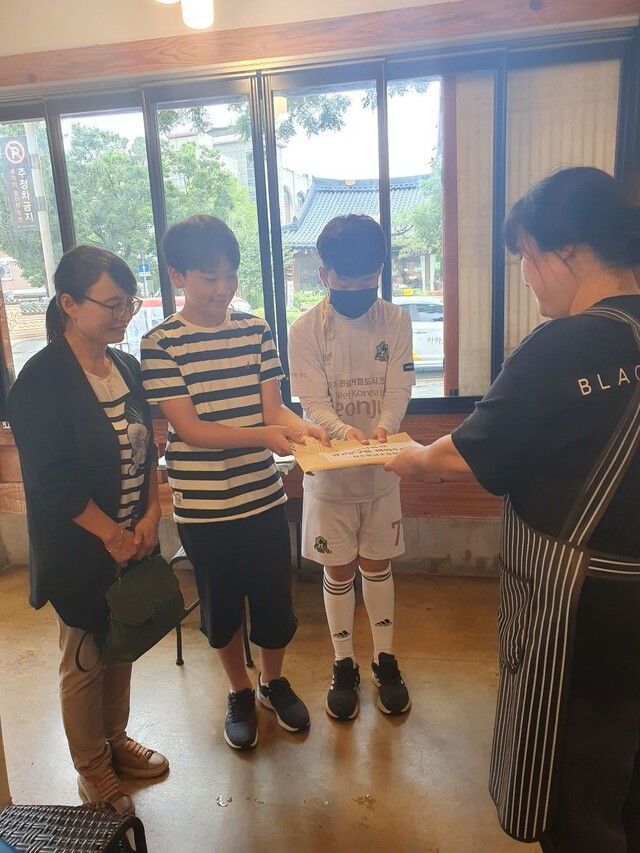 전주 풍남초등학교 학생들이 자신들이 쓴 편지를 가게 주인에게 전달하고 있다. [사진출처=전북교육청 제공]
