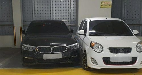 주차선을 넘어온 BMW 차량 옆에 경차가 주차돼 있다.[사진=연합뉴스]